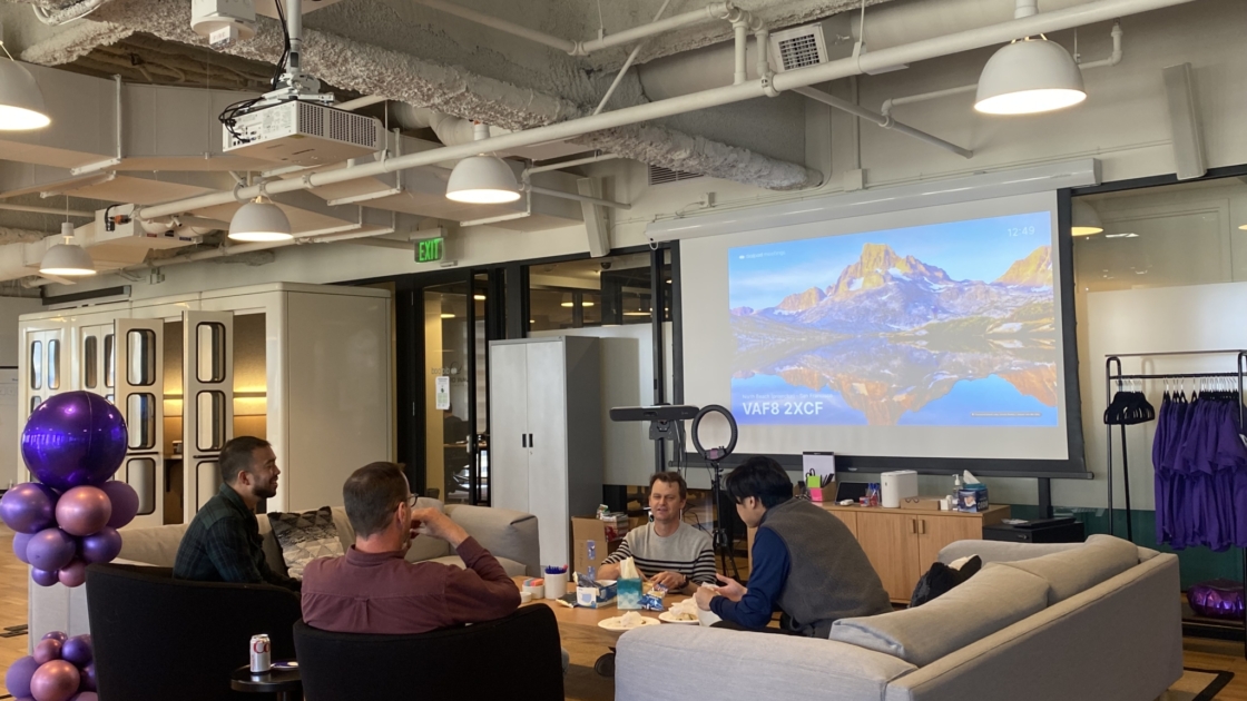 Dialpad Mitarbeiter im WeWork Büro in San Francisco sitzen um einen großen Couchtisch in einem Loungebereich.
