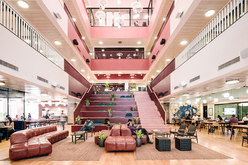 Öppna sittplatser och trappa mitt i ett gemensamt WeWork-utrymme i rosa nyanser