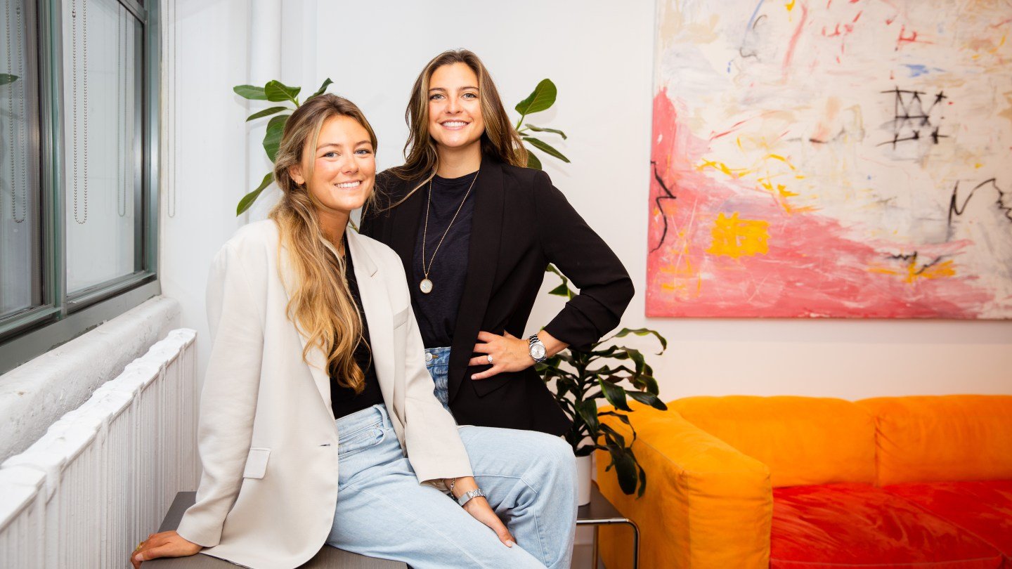 Naylor sisters in front of plant and painting