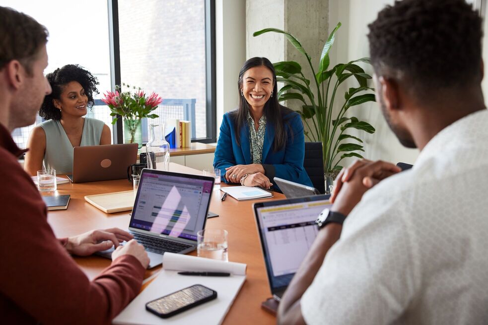 People smiling in a meeting room.