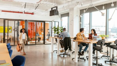 woman arriving to work while others are already working in a WeWork space
