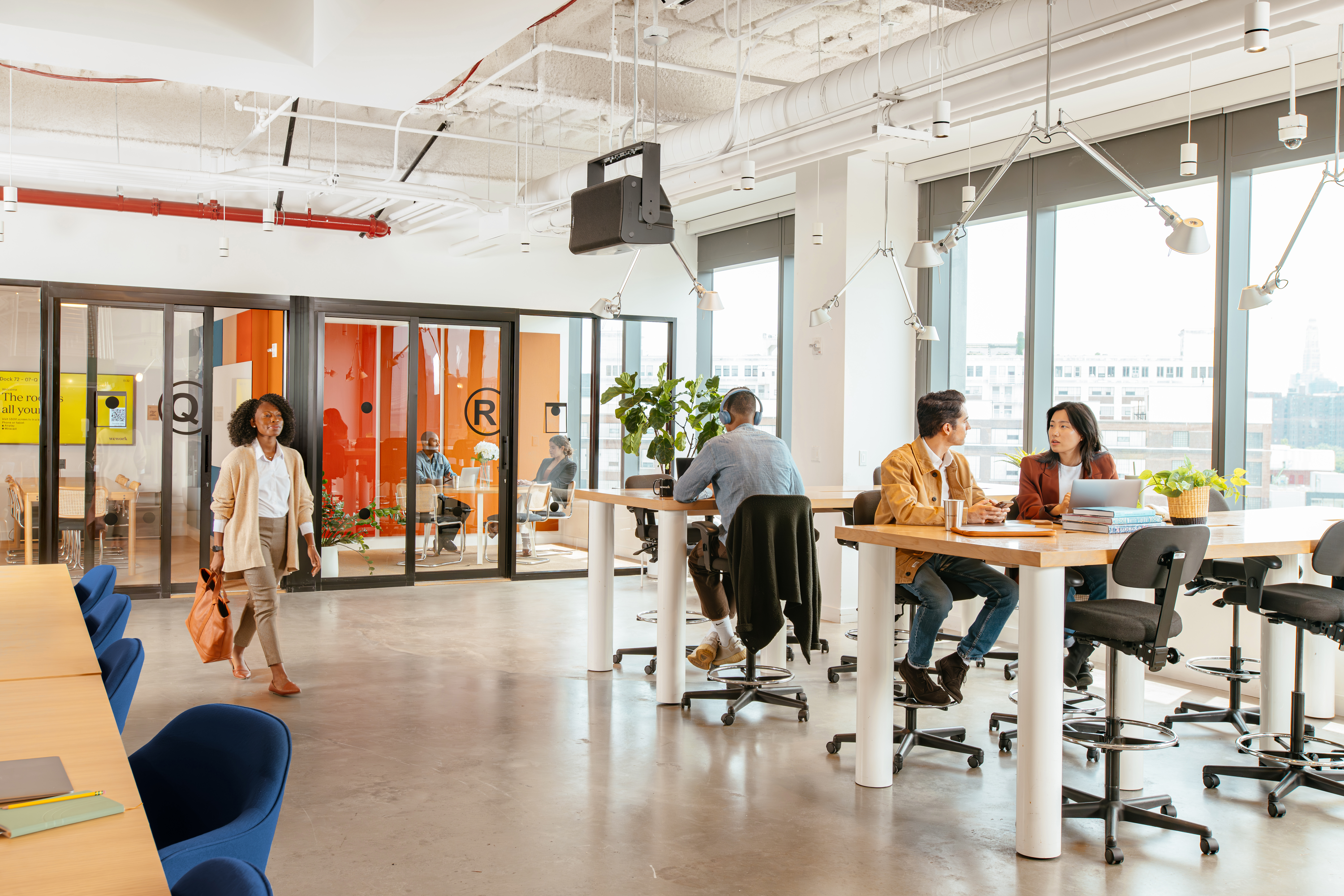 woman arriving to work while others are already working in a WeWork space