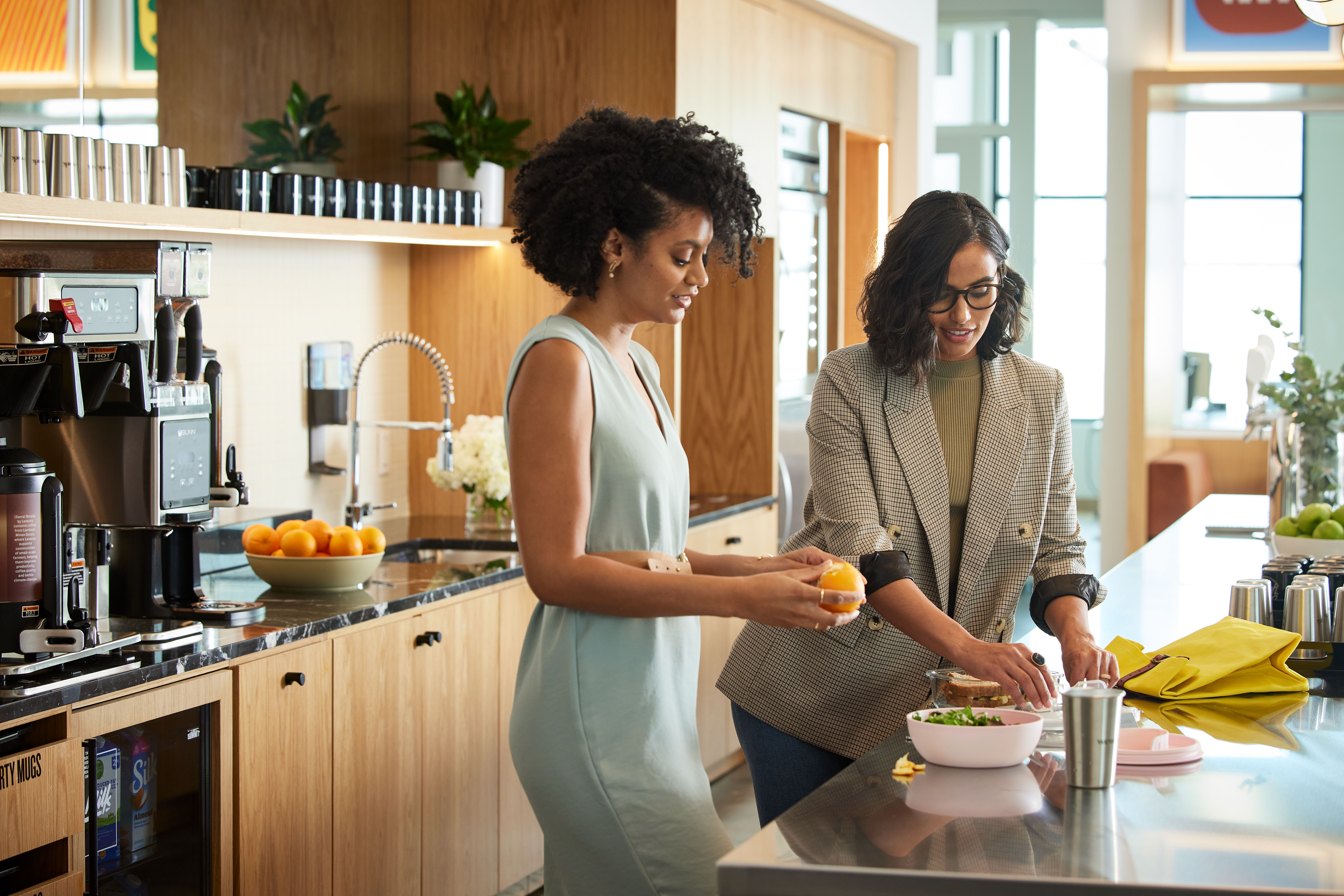 two WeWork members preparing for a lunch break in a shared kitchen