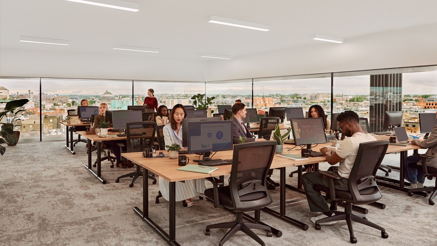 people at assigned desks in a WeWork workspace