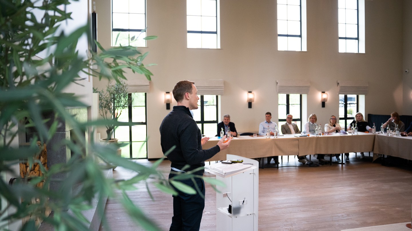 WeWork summit featuring speaker and participants sitting at the table
