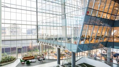 Office building with floor-to-ceiling windows, seen from outside.