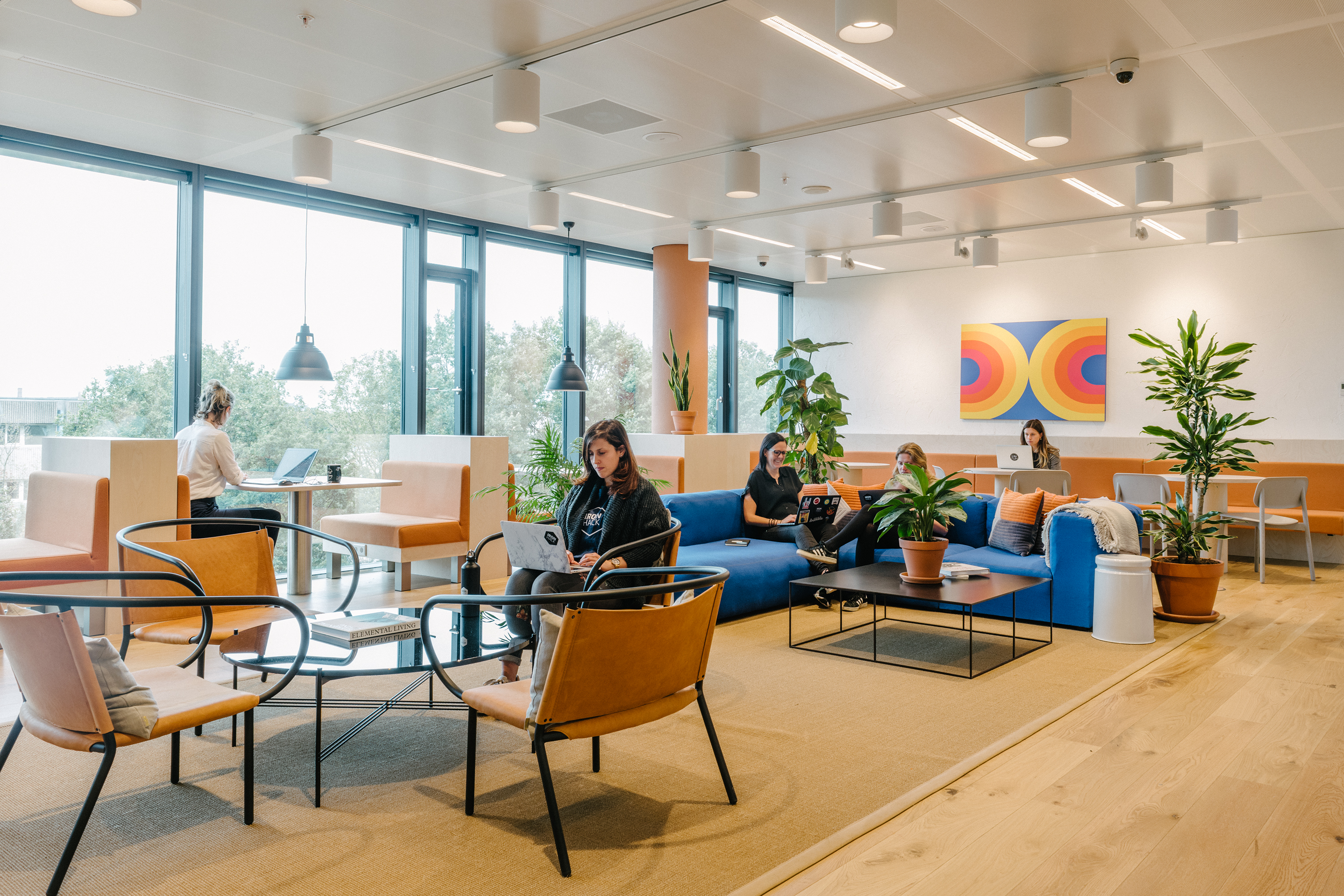 people working in different areas of a coworking space