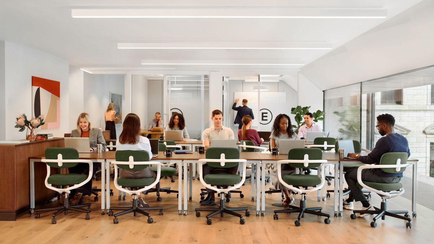 People sitting at their desks in an open coworking space.