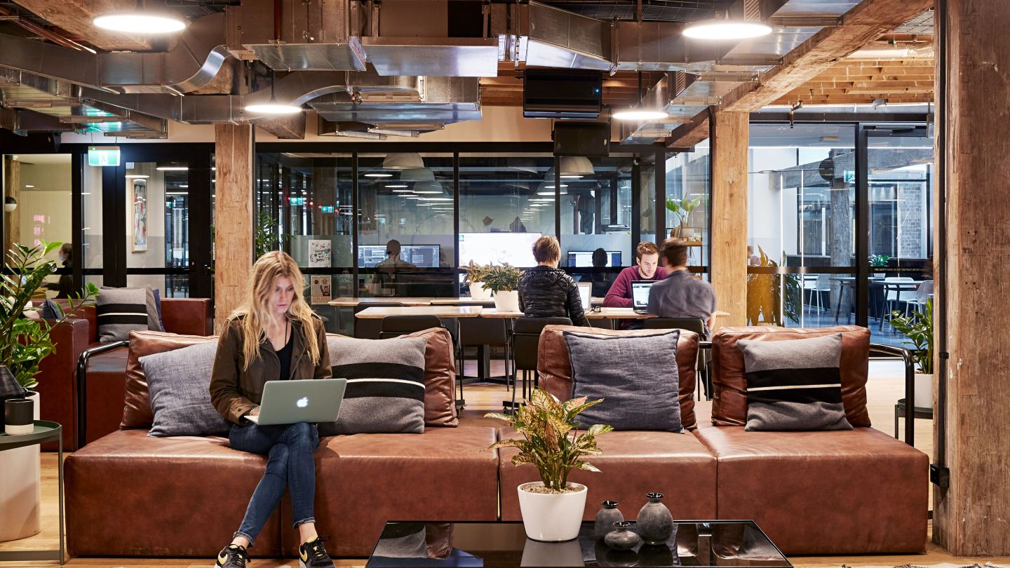 people working in common lounges, shared desks and meeting rooms at WeWork 100 Harris St