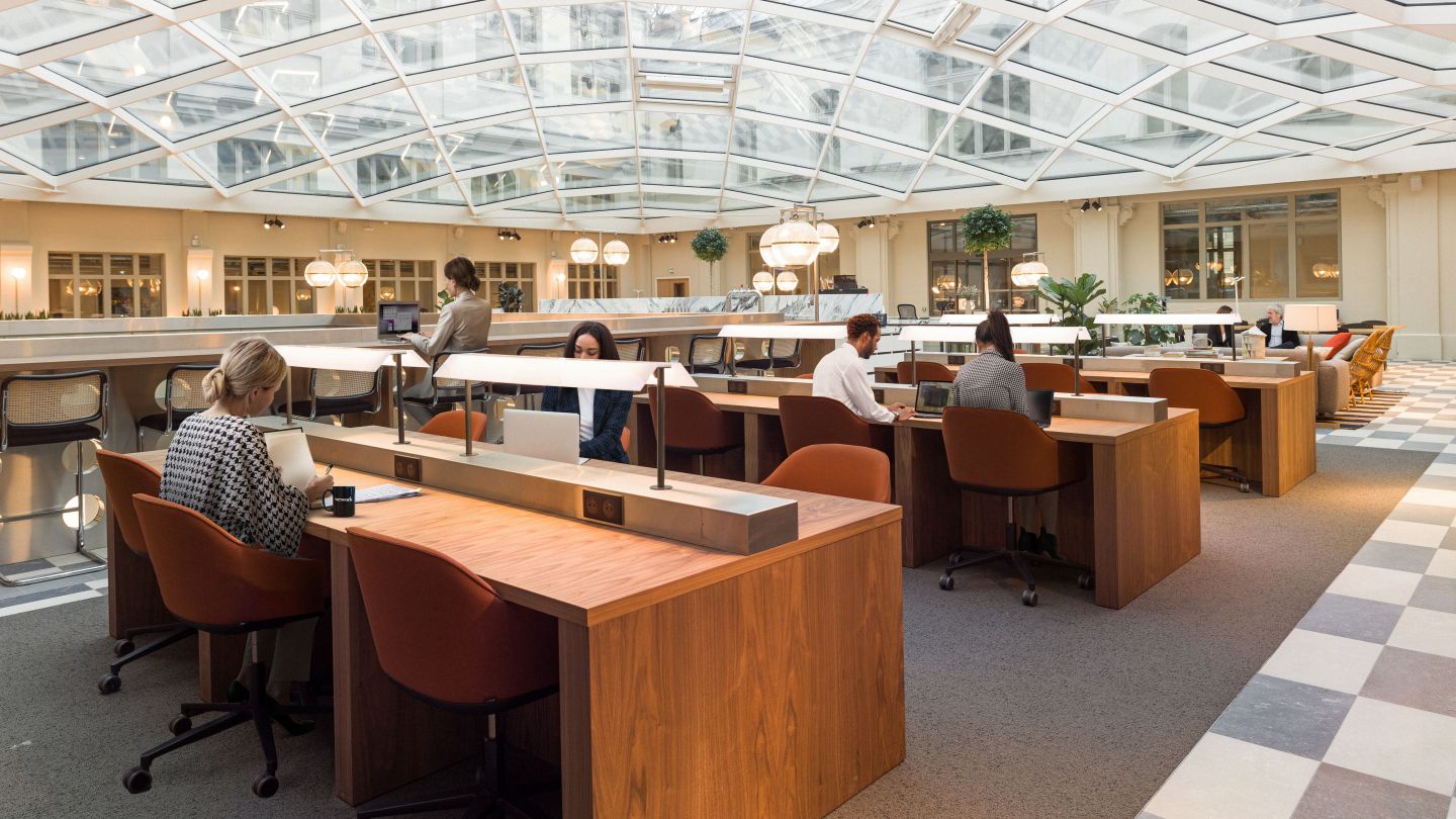 people working in a WeWork shared space with glass ceiling