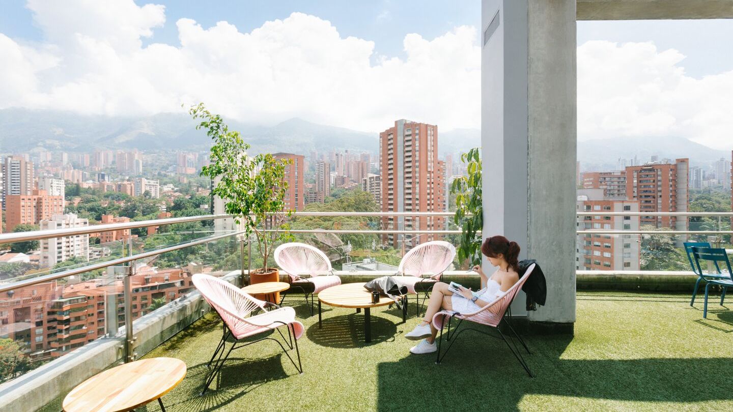 A WeWork member sitting on rooftop terrace overlooking the city.