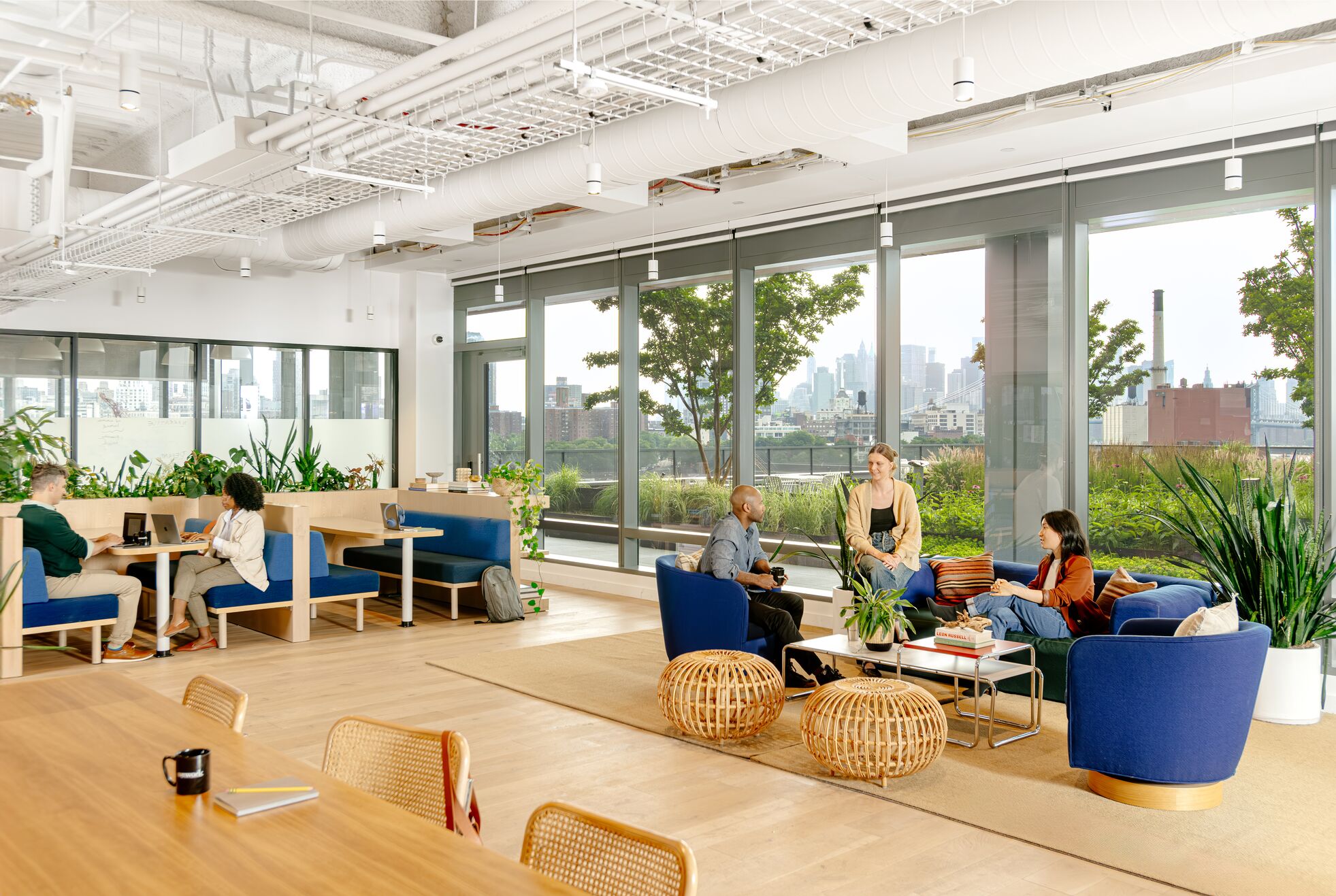 Bright, expansive lounge area with wood furniture and many plans.